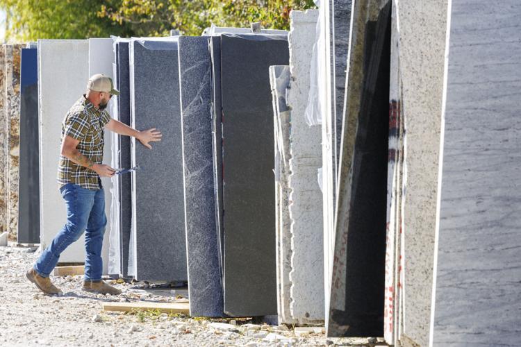 man looking at stone slabs